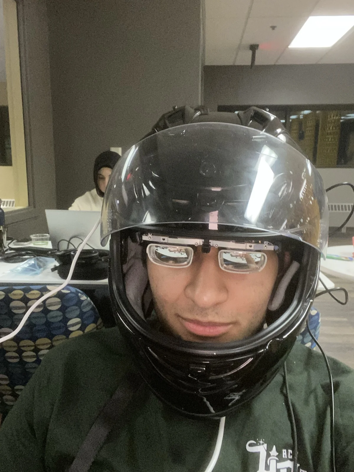The helmet and XREAL glasses being worn at the hackathon worktable